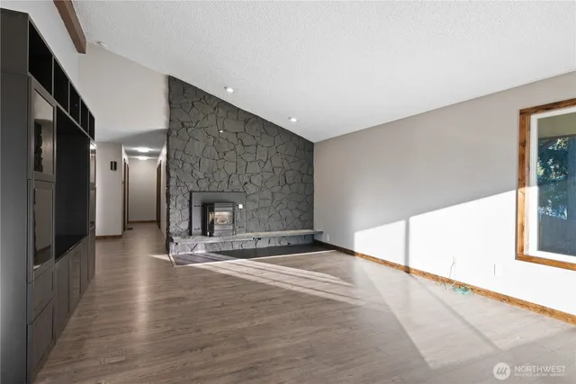 a view of an empty room with a fireplace and a window