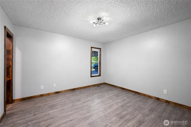 an empty room with wooden floor and a window