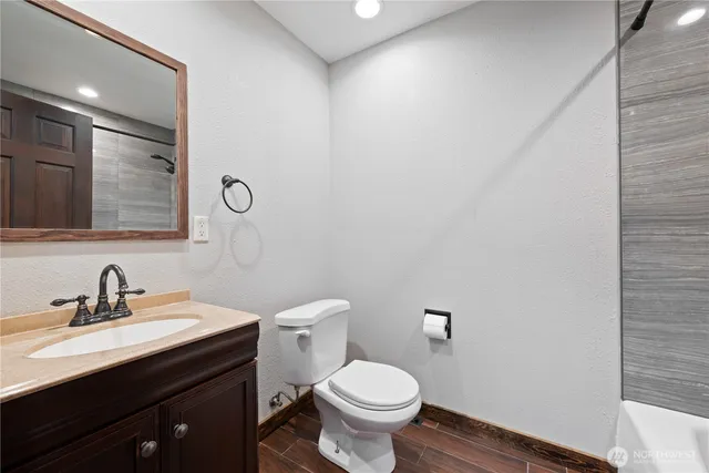 a bathroom with a toilet a sink and mirror