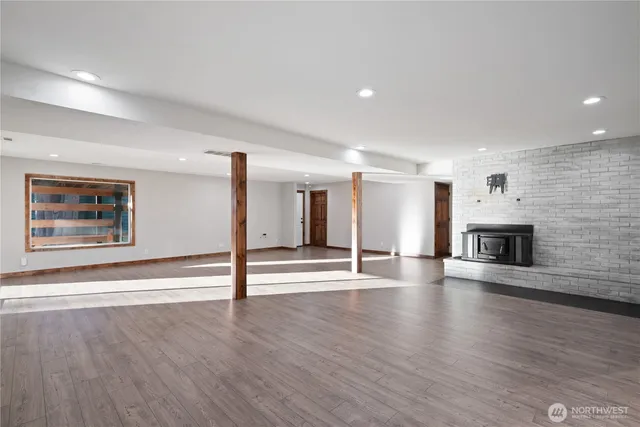 an empty room with wooden floor and fireplace
