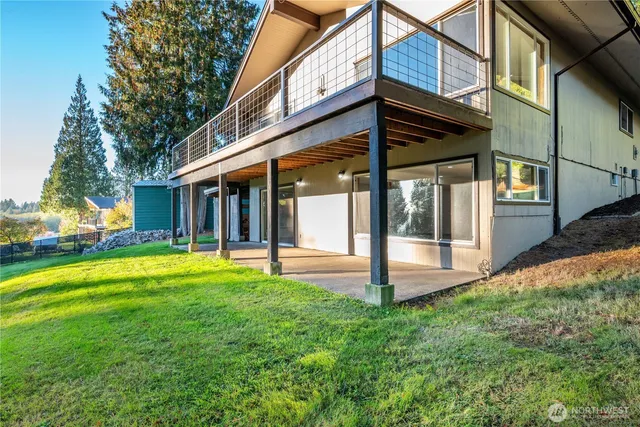 a view of a white house with a big yard and large trees