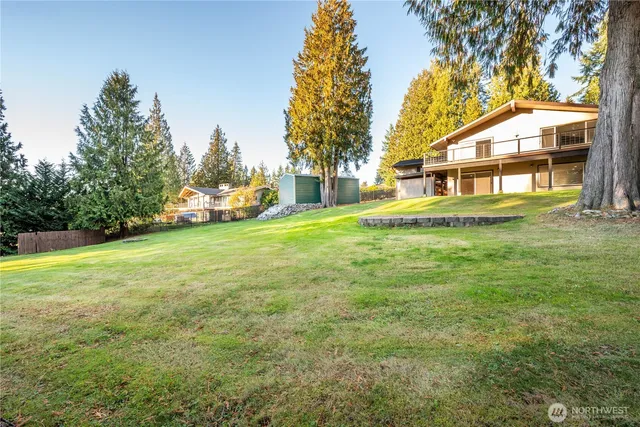 a view of a house with a yard and basketball court
