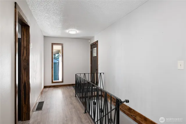 a view of a hallway with wooden floor and stairs