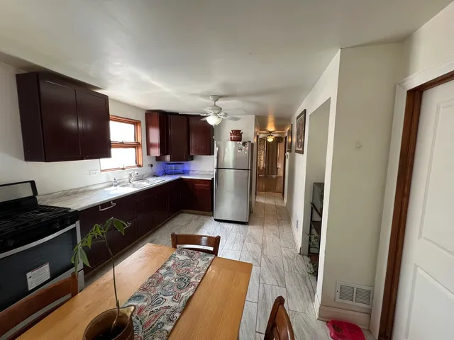 a kitchen with a refrigerator and a stove top oven
