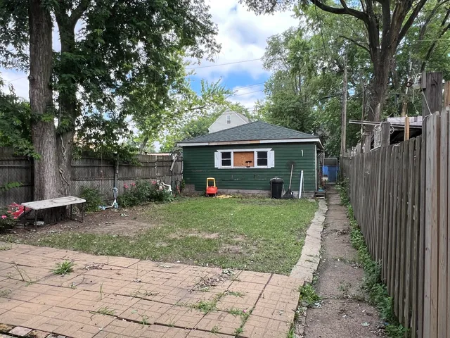 a front view of a house with a garden and trees