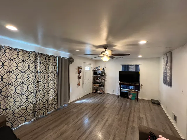 a view of a livingroom with wooden floor and a flat screen tv