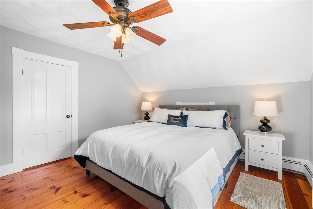 13 State Street Peabody, MA 01960 - Photo 19 of 42 a bedroom with a bed and a chandelier