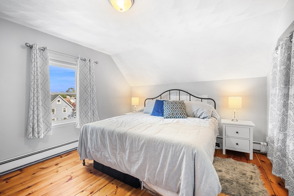 13 State Street Peabody, MA 01960 - Photo 25 of 42 a bedroom with a bed and wooden floor
