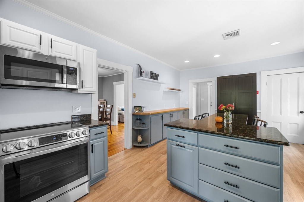 13 State Street Peabody, MA 01960 - Photo 5 of 42 a kitchen with stainless steel appliances white cabinets and a stove top oven