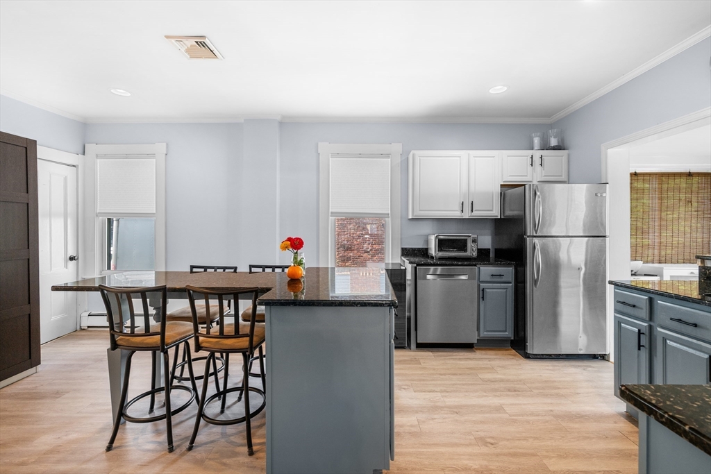 13 State Street Peabody, MA 01960 - Photo 6 of 42 a kitchen with a refrigerator a table and chairs