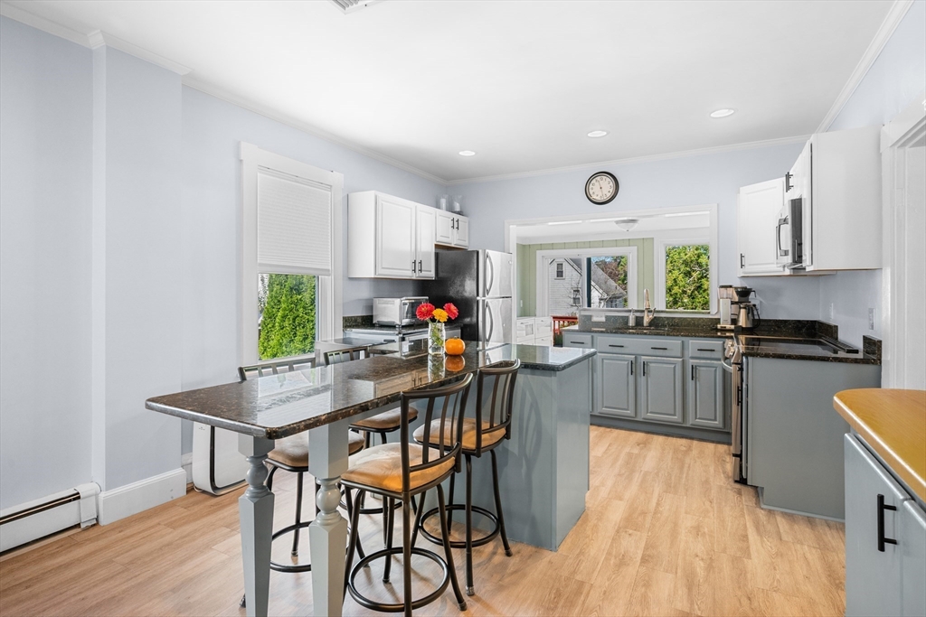 13 State Street Peabody, MA 01960 - Photo 7 of 42 a kitchen with a table chairs microwave and cabinets