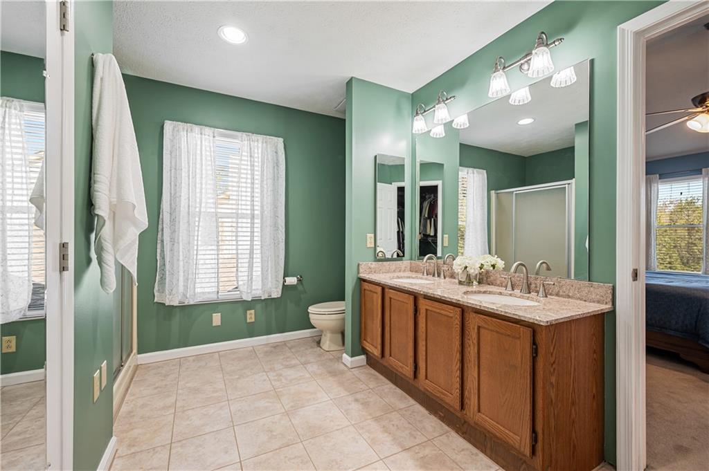121 Tiffany Ridge Drive Coraopolis, PA 15108 - Photo 17 of 28 The primary bathroom includes a granite double sink vanity, tiled floors, a walk-in shower and a walk-in closet.