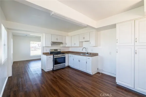 a kitchen with sink a microwave and cabinets