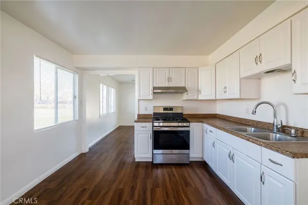 a kitchen with stainless steel appliances granite countertop a sink a stove and cabinets