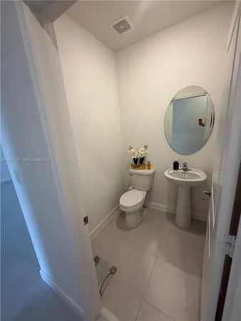 a bathroom with a toilet a sink and mirror
