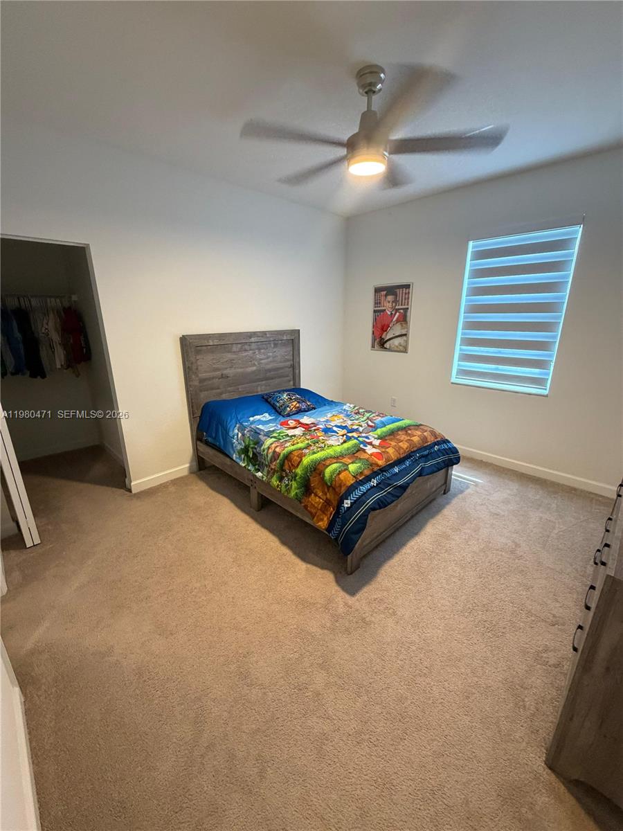 16751 Southwest 291st Terrace, Unit 16751 Homestead, FL 33030 - Photo 9 of 20 a bedroom with a bed and a tv on the dresser