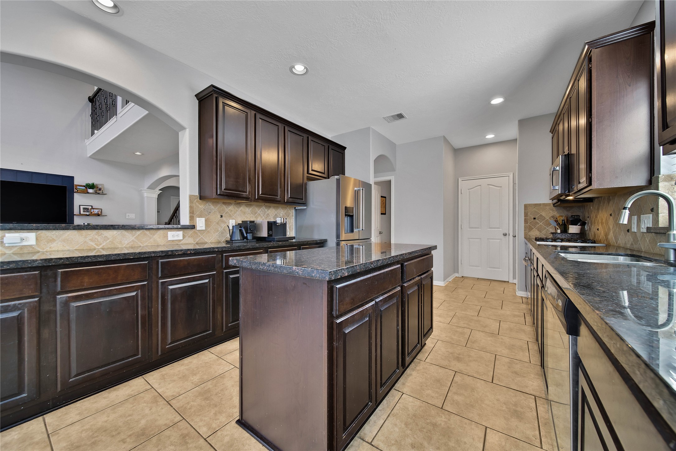 21715 Flecherwood Court Spring, TX 77388 - Photo 14 of 43 a kitchen with granite countertop cabinets stainless steel appliances and a sink