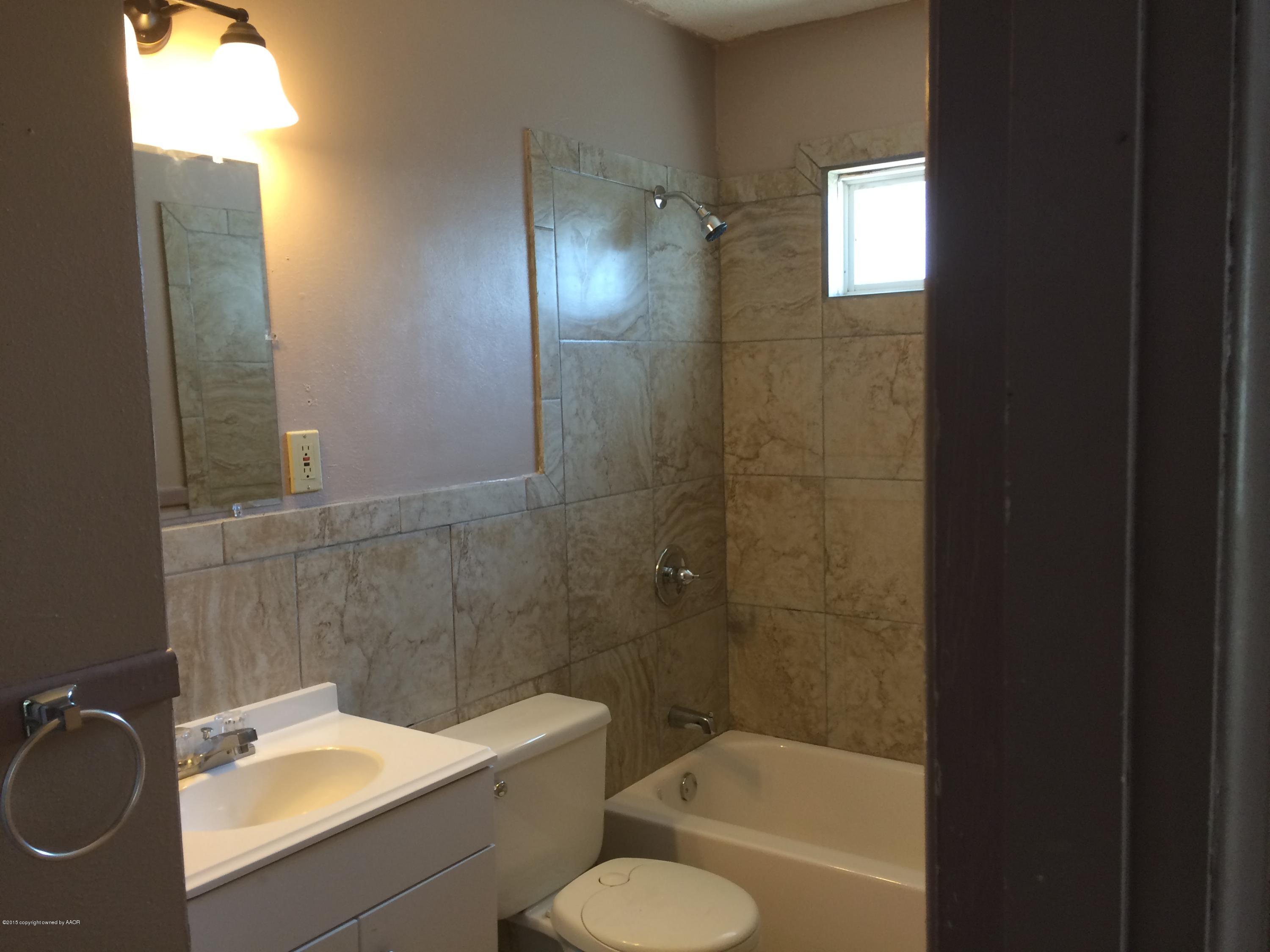 4635 South Hayden Street Amarillo, TX 79110 - Photo 10 of 10 a bathroom with a sink a toilet and shower