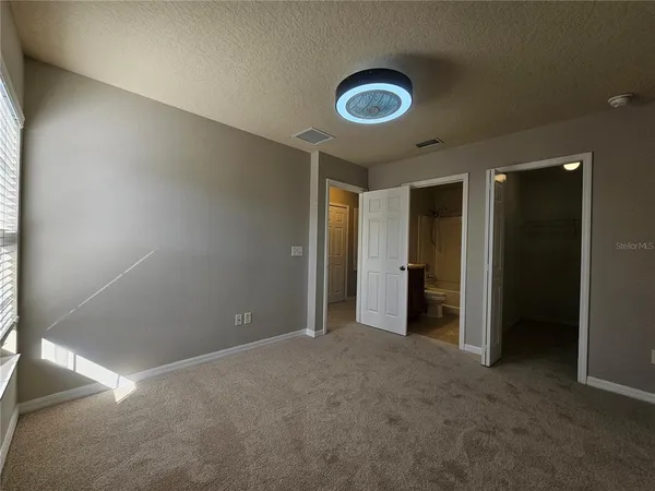 an empty room with closet and bathroom view