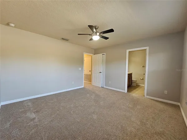 an empty room with a ceiling fan and a window