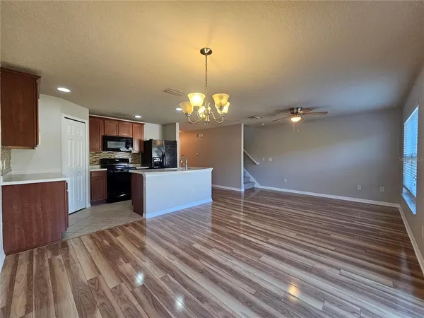 a view of kitchen with granite countertop cabinets and refrigerator