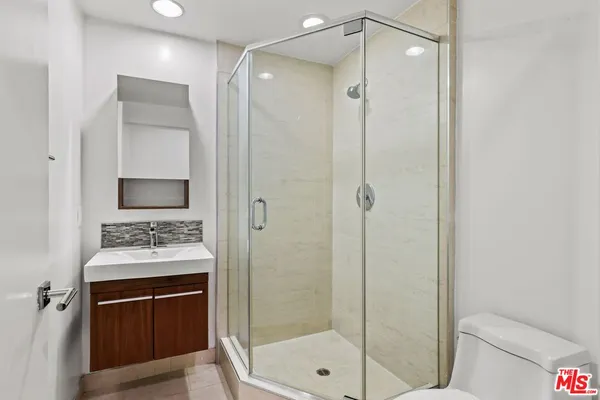a bathroom with a shower sink vanity and mirror