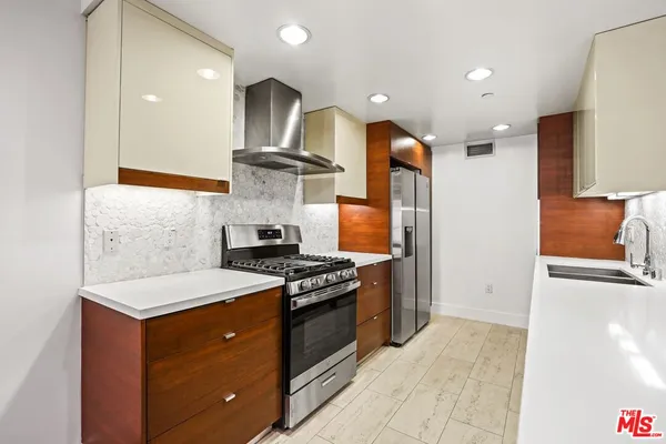 a kitchen with stainless steel appliances granite countertop a stove a sink and a refrigerator