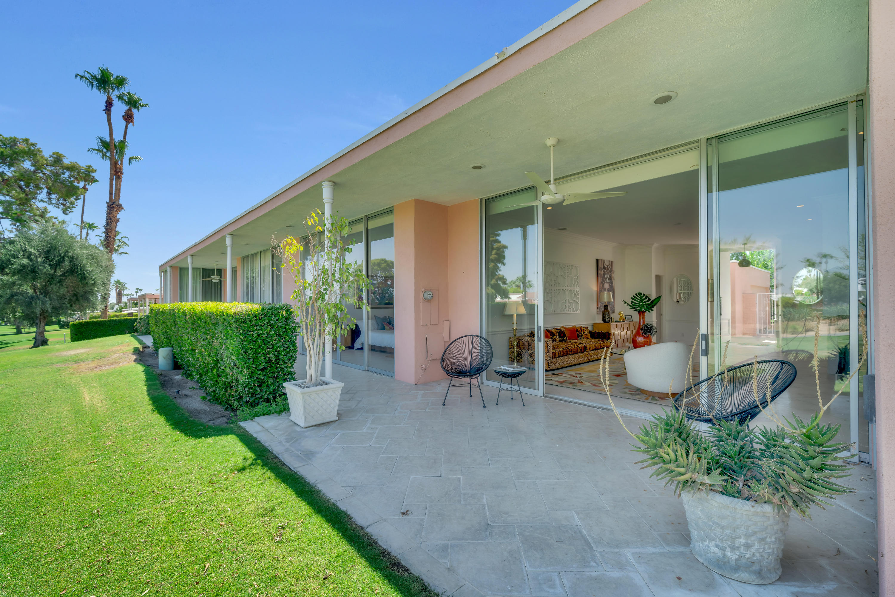 47420 Rabat Drive Palm Desert, CA 92260 - Photo 28 of 50 a view of a patio with table and chairs potted plants and a large tree