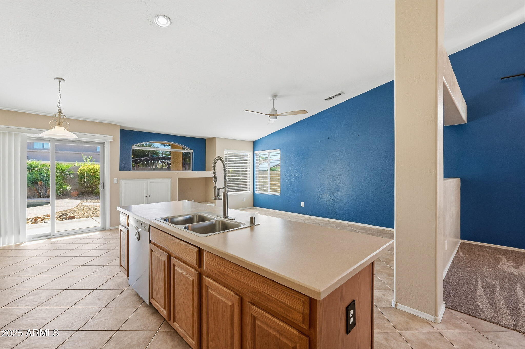 17509 West Rock Ledge Road Goodyear, AZ 85338 - Photo 15 of 55 a kitchen with stainless steel appliances granite countertop a stove a refrigerator and a view of living room
