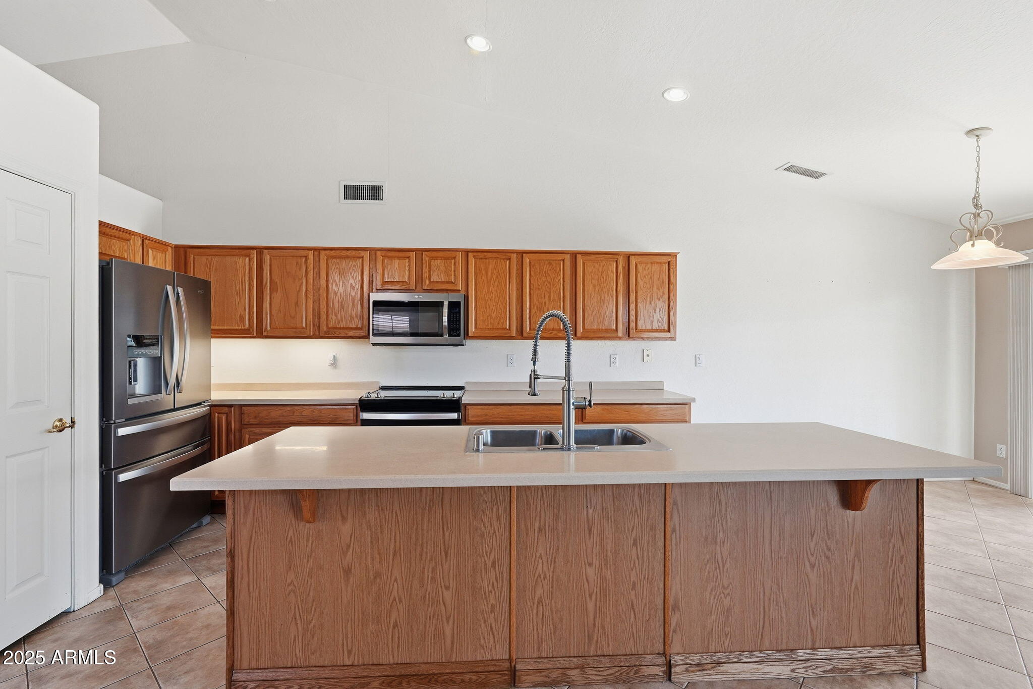17509 West Rock Ledge Road Goodyear, AZ 85338 - Photo 18 of 55 a kitchen with stainless steel appliances a refrigerator and a stove top oven