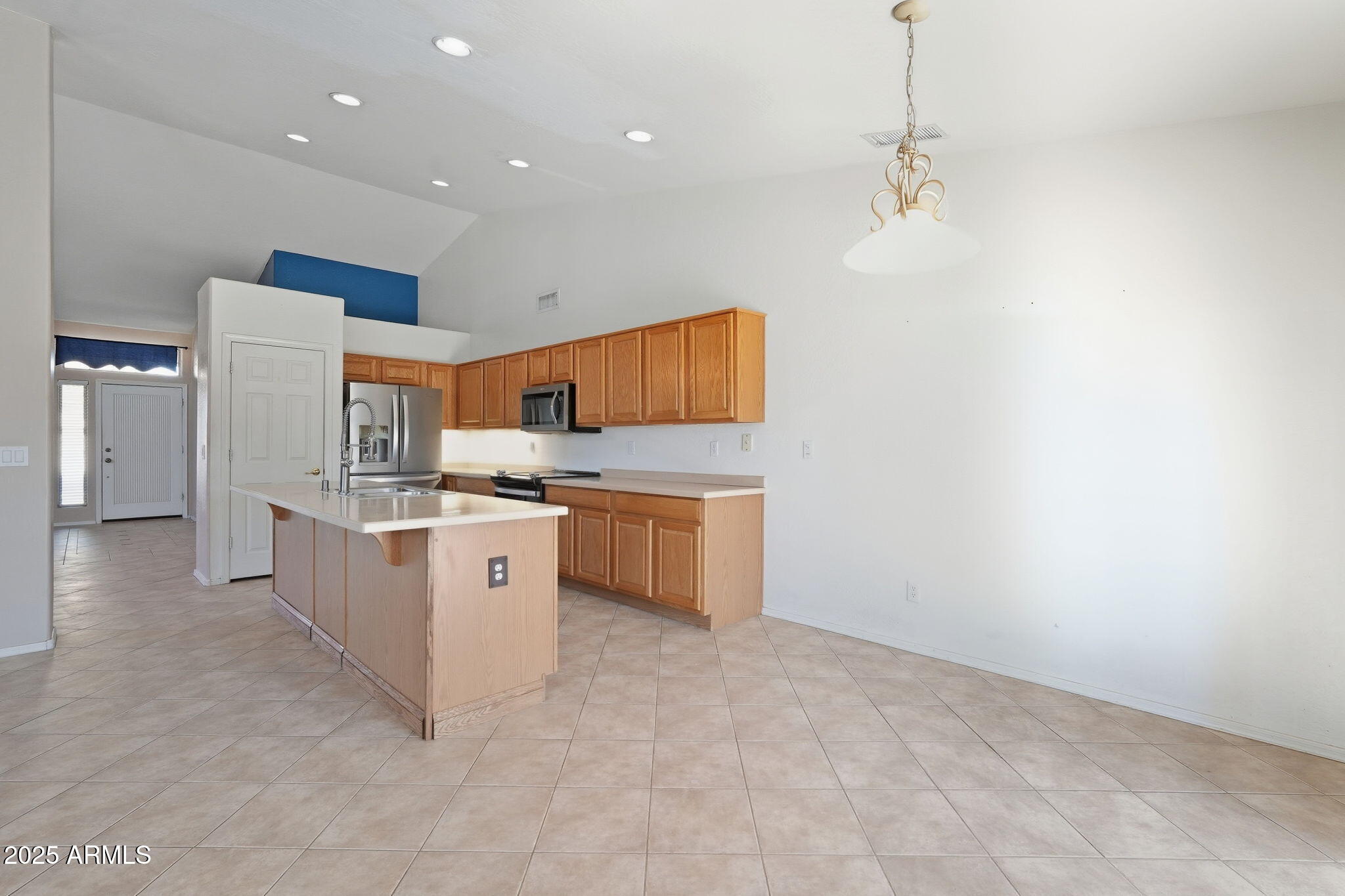 17509 West Rock Ledge Road Goodyear, AZ 85338 - Photo 19 of 55 a kitchen with stainless steel appliances a white stove top oven a sink a refrigerator and a window
