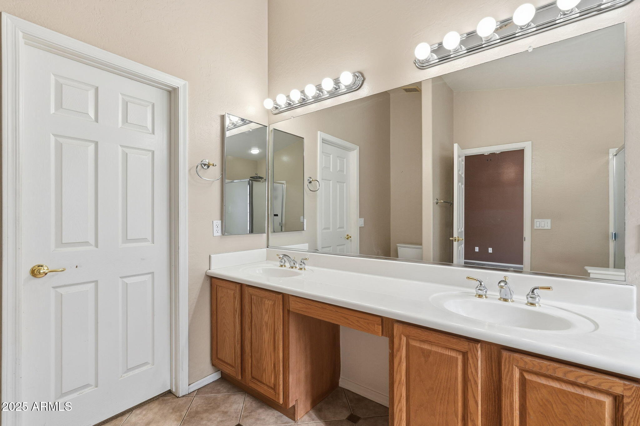 17509 West Rock Ledge Road Goodyear, AZ 85338 - Photo 34 of 55 a bathroom with double vanity sinks and a mirror