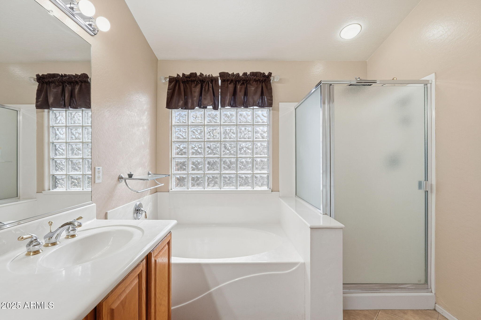 17509 West Rock Ledge Road Goodyear, AZ 85338 - Photo 35 of 55 a bathroom with a sink a bathtub a shower and a window