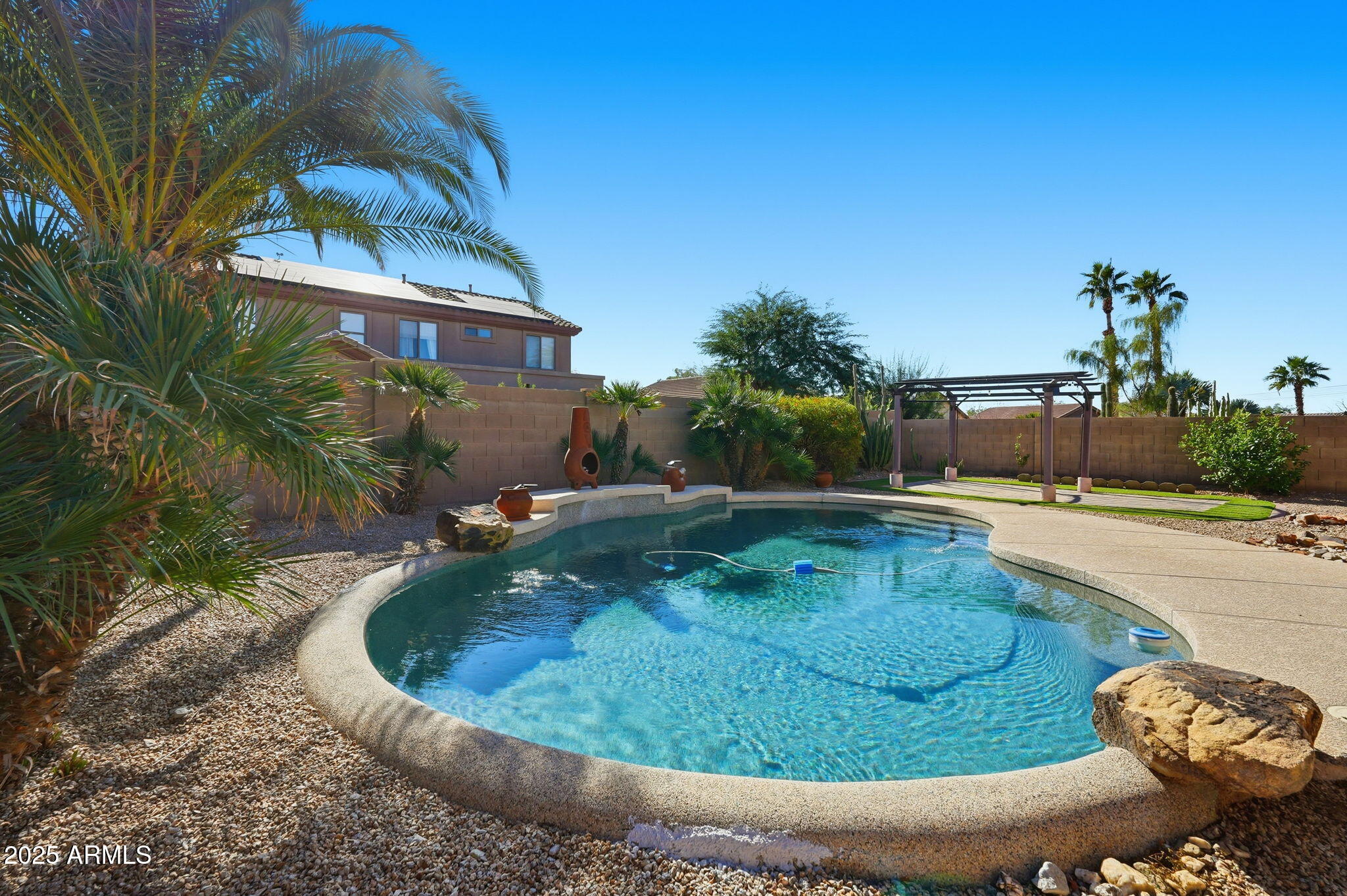 17509 West Rock Ledge Road Goodyear, AZ 85338 - Photo 44 of 55 a view of a swimming pool with a yard