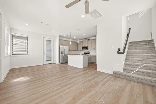 a view of a kitchen with wooden floor and electronic appliances