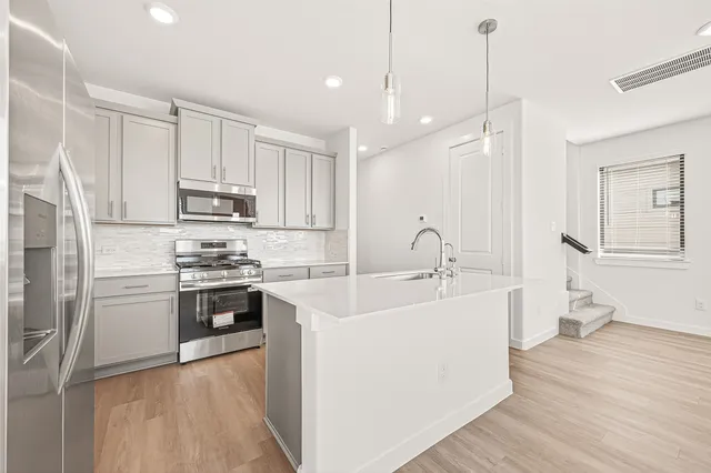 a kitchen with stainless steel appliances sink a microwave and cabinets