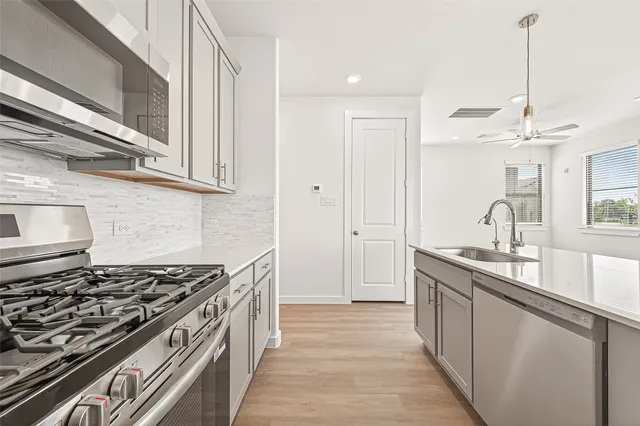 a kitchen with stainless steel appliances granite countertop a sink stove and cabinets