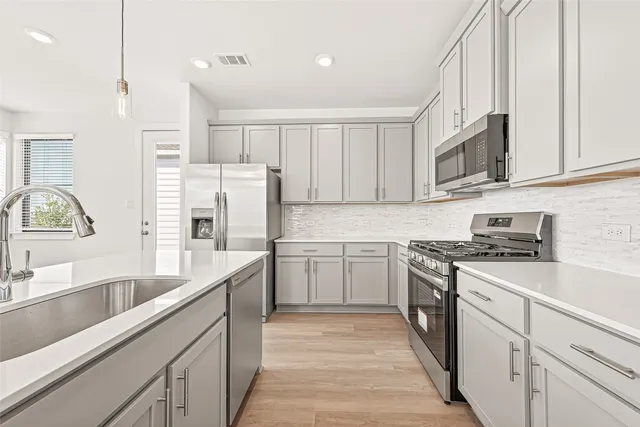 a kitchen with stainless steel appliances granite countertop a sink stove and refrigerator