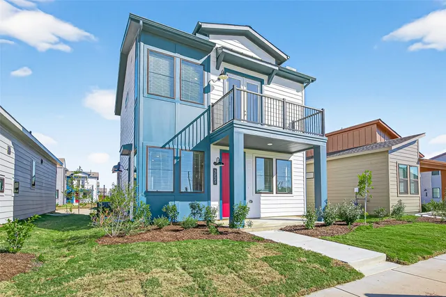 a view of a white house with a small yard and plants