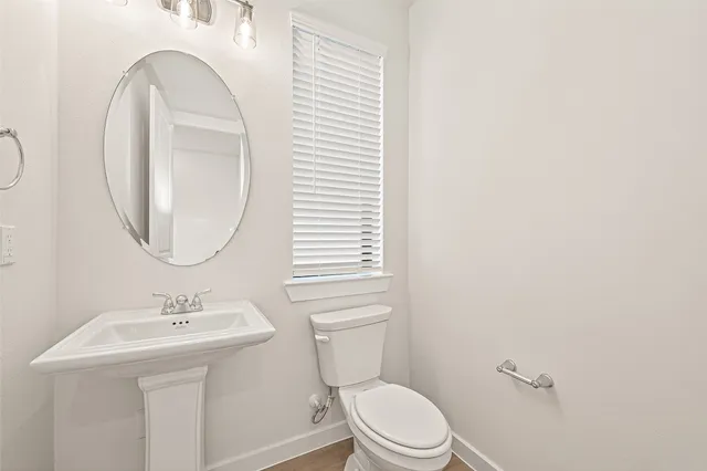 a bathroom with a toilet a sink and a mirror