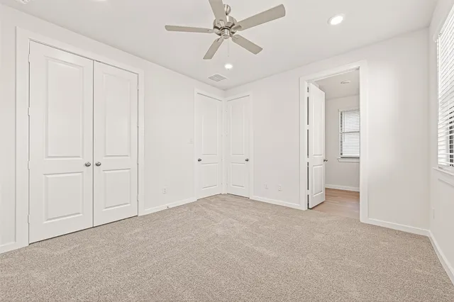 an empty room with fan and entryway