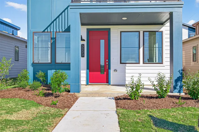 a front view of a house with a yard and potted plants