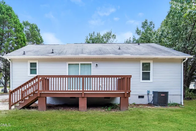 a view of a house with a yard and a deck