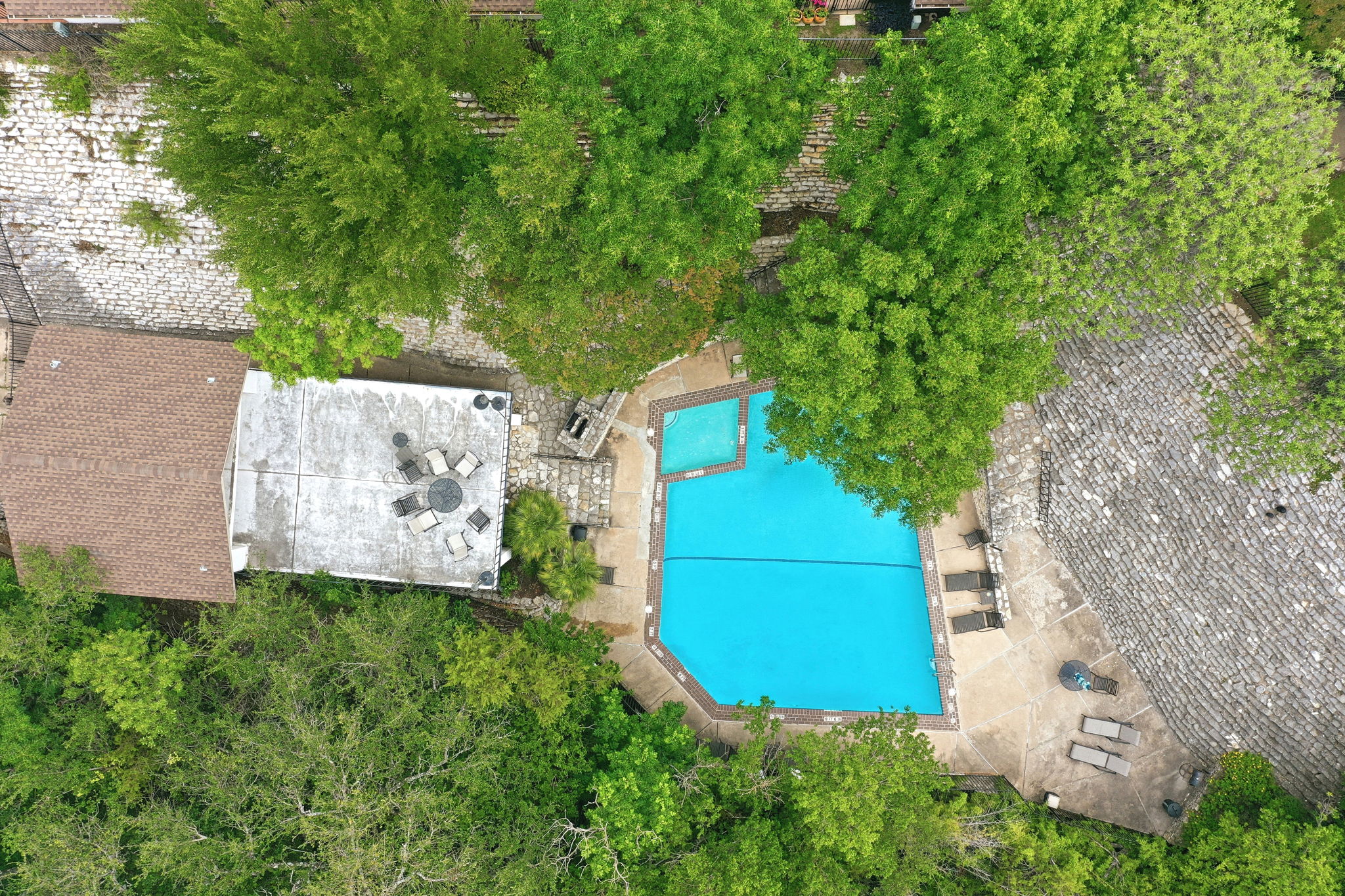 6910 Hart Lane, Unit 912 Austin, TX 78731 - Photo 33 of 36 Geometric swimming pool with integrated spa, surrounded by stone paver decking and mature trees