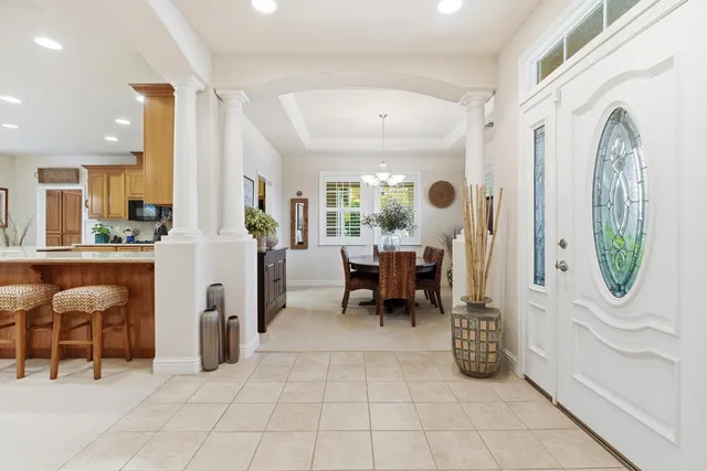 a dining room with furniture a chandelier and window