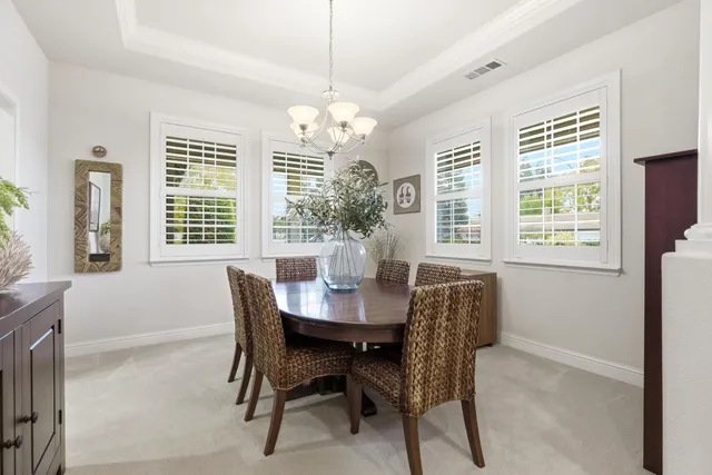 a view of a dining room with furniture and a chandelier