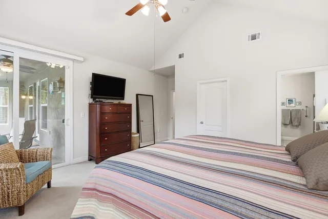 a spacious en suite bathroom with a granite countertop double vanity sink a mirror and a bathtub
