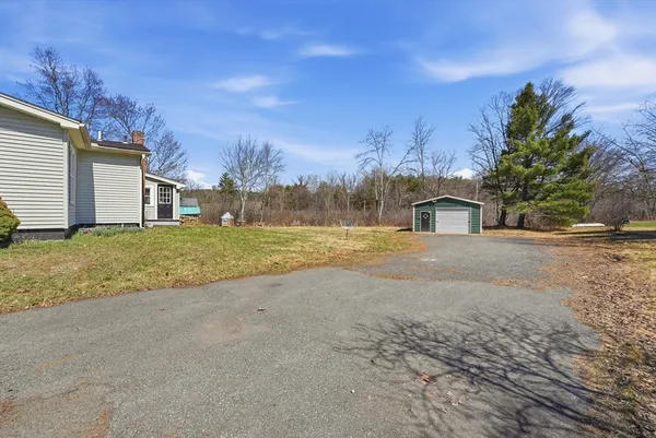 a view of a house with backyard and trees