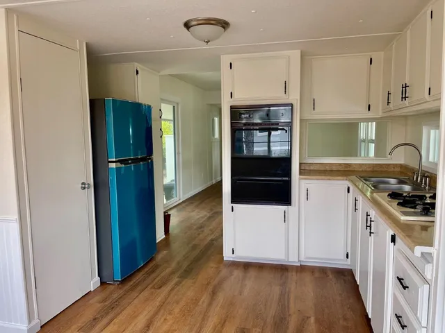 a kitchen with white cabinets and appliances