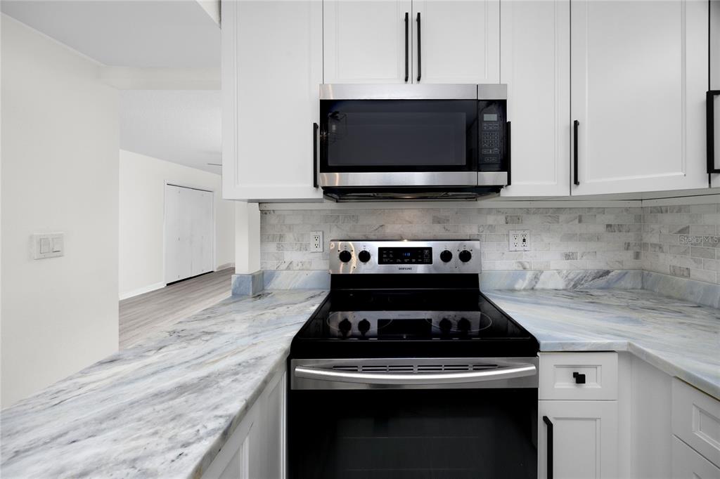 2207 Belleair Road, Unit B4 Clearwater, FL 33764 - Photo 6 of 37 a kitchen with microwave cabinets and a stove top oven